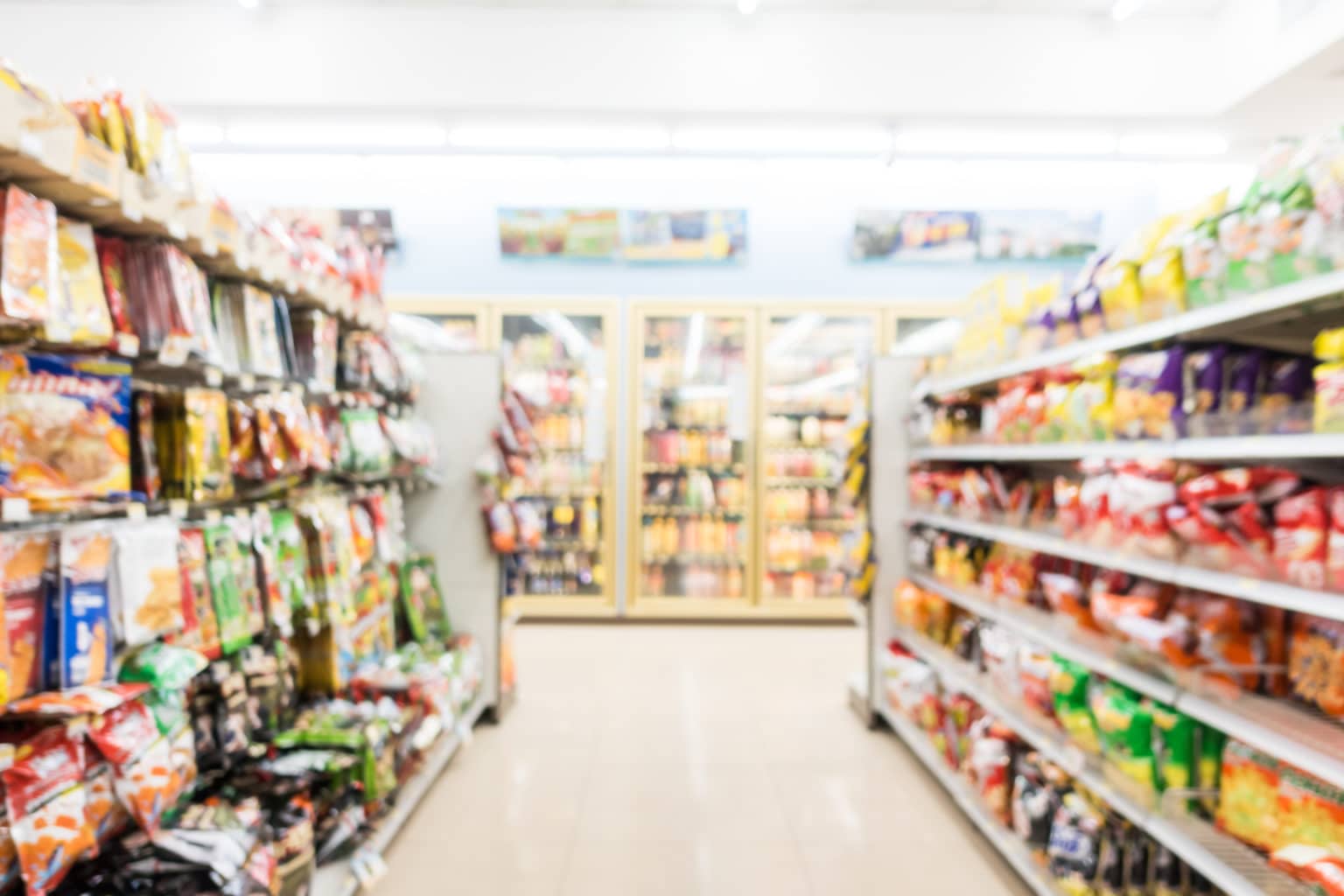 Aisles and shelves filled with various food products in side grocery convenience store.