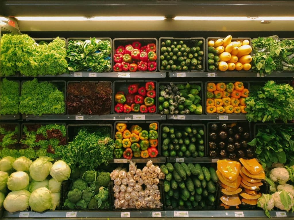 Grocery store produce section with rows and shelves of vegetables.