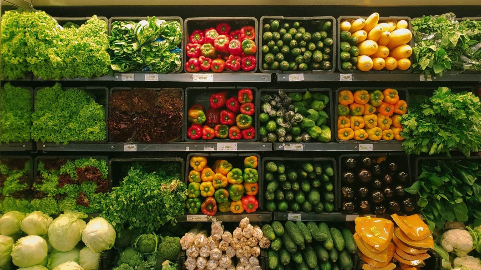 Grocery store produce section with rows and shelves of vegetables.