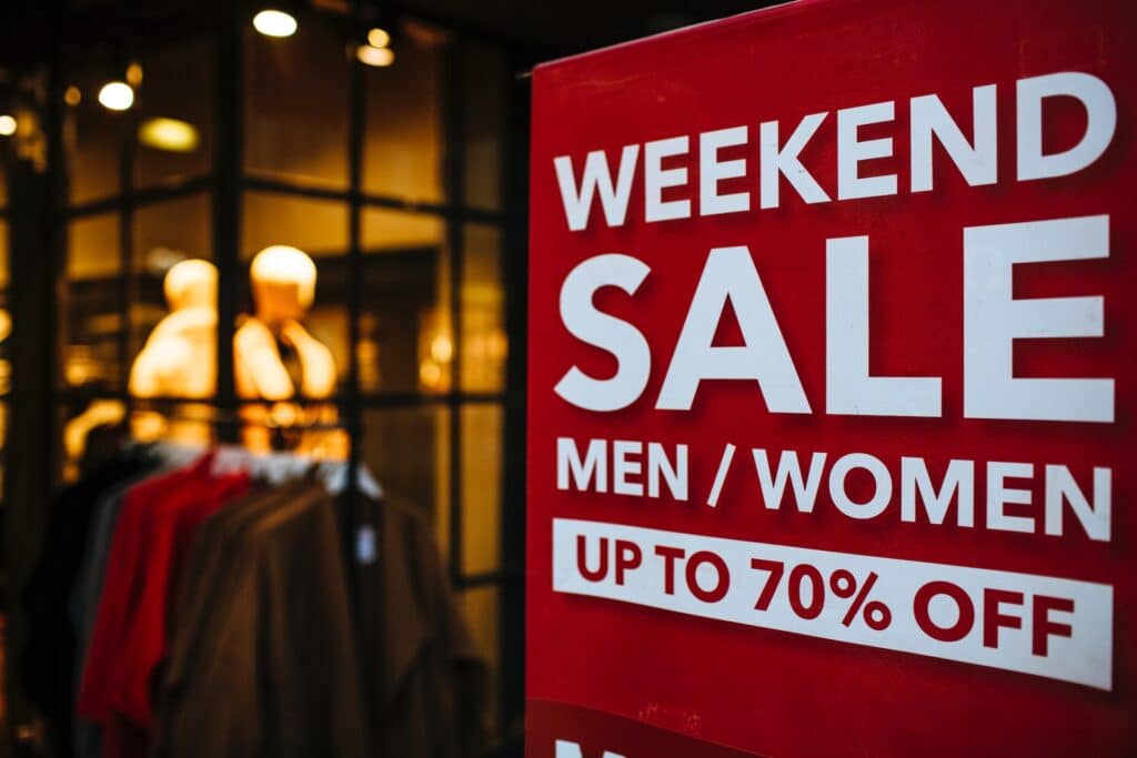 Red sign outside a store advertising a weekend sale; test and learn software can determine if a promotion will produce positive lift.