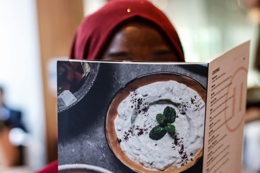 A woman looks at a menu. Test and learn for restaurants can aid in innovation and menu development.
